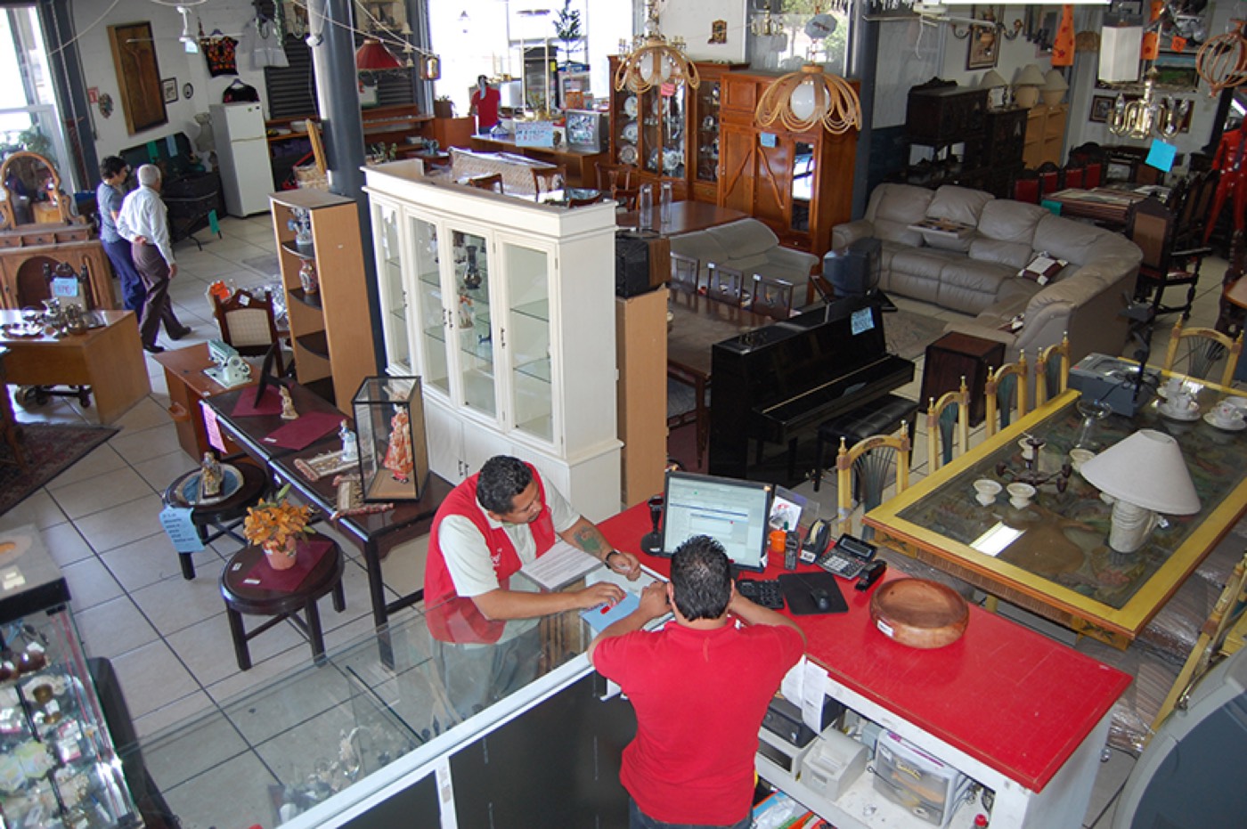 Piso de venta de Tesoros Bazar con muebles, pianos y personal atendiendo en el mostrador
