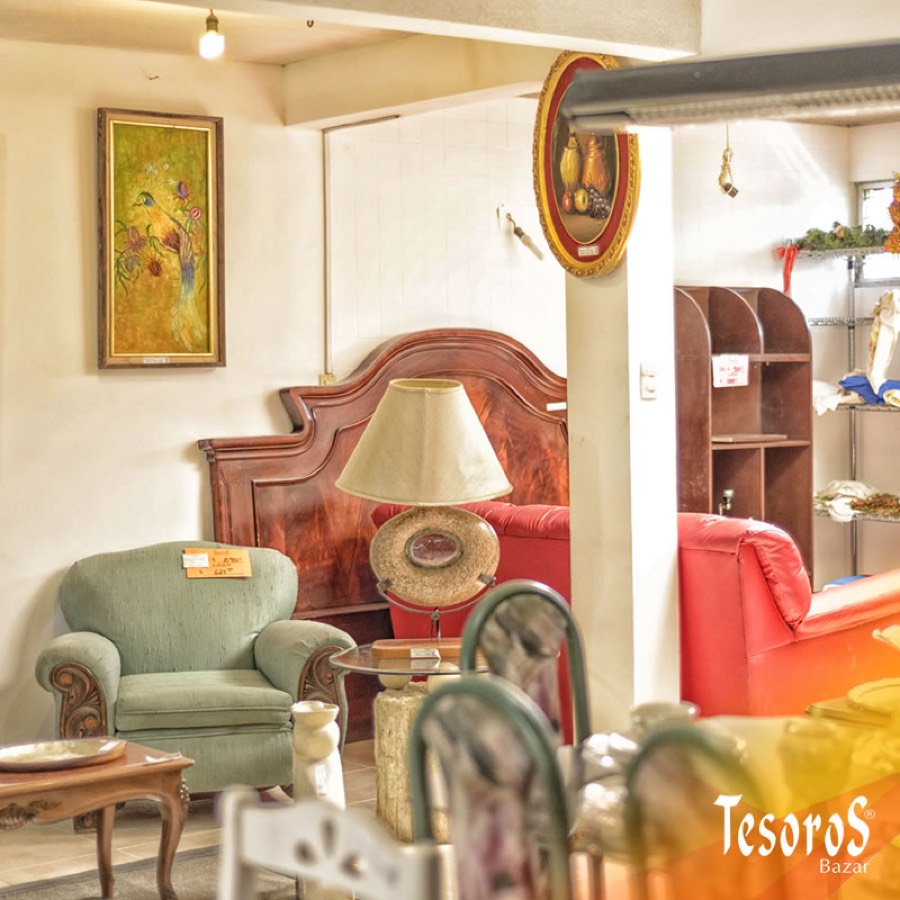 Interior de una tienda Tesoros Bazar con muebles, cuadros y sillones en exhibición