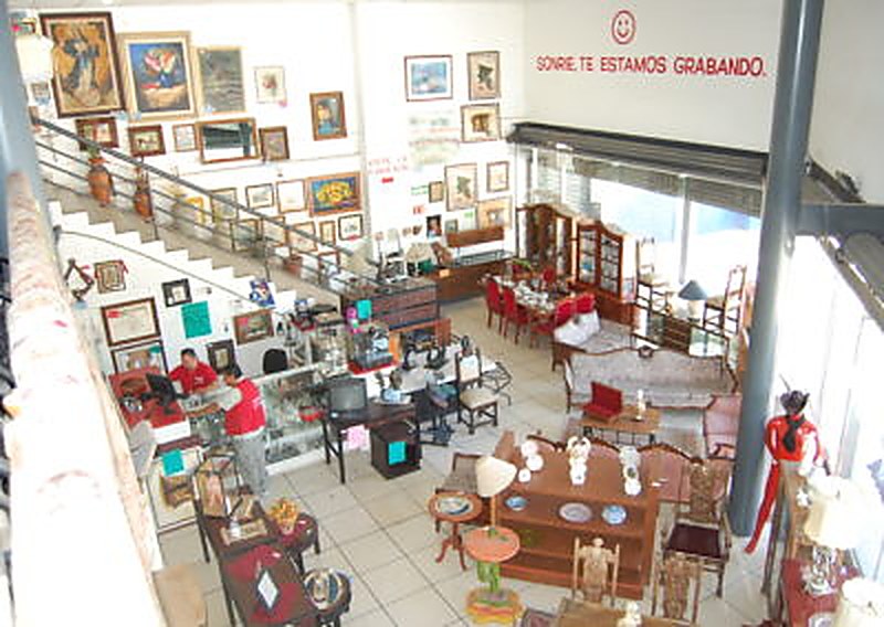 Interior de la sucursal Tesoros Bazar en Blvd. San Pedro: piso de venta amplio con muebles, cuadros y artículos en exhibición